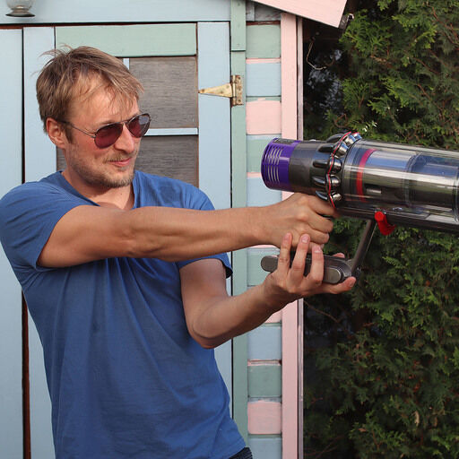 Joe hält einen Dyson Akkustaubsauger in der Hand